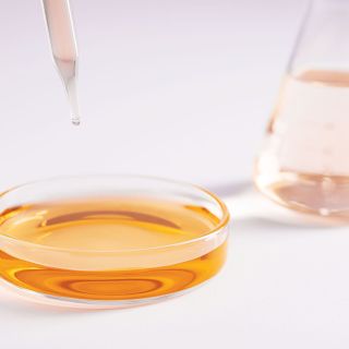closeup-shot-glass-dish-with-yellow-liquid-dropper-lab